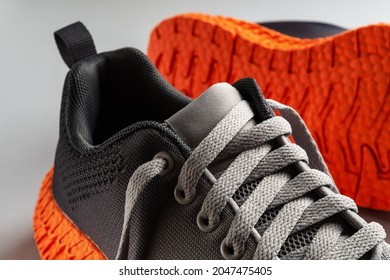 Elastic Laces Of Gray Mesh Fabric Sneakers With Orange Grooved Sole Close-up. Lacing Up The Modern Textile Trainers For Sport, Fitness And Active Lifestyle. Pair Of New Stilysh Sport Shoes.