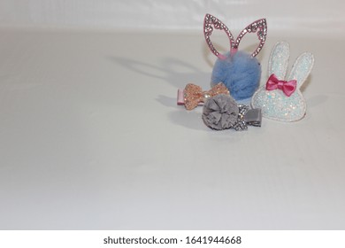 Elastics And Stilettos On A White Background. Baby Hair Ornaments. Girl Accessories Near The Casket. Hairpins, Earrings, Rings Are The Treasures Of A Little Girl. Baby Jewelry