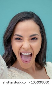 Elated, Excited Beautiful Young Woman Against A Solid Background