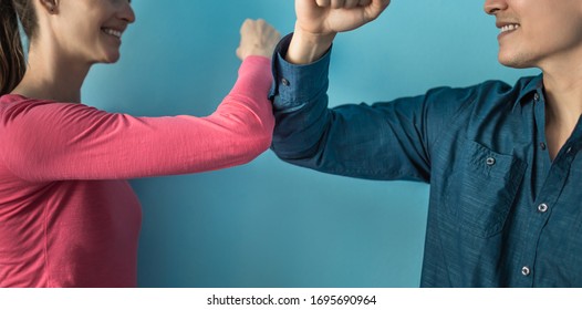 Elbow Bump Greeting To Avoid The Spread Of Coronavirus. Two People Friends Greet By Bumping Elbows Instead Of Greeting With A Hug Or Handshake. Don't Shake Hands. 