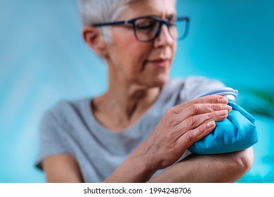 Elbow Pain Treatment. Senior Woman Holding An Ice Bag Compress On A Painful Elbow 