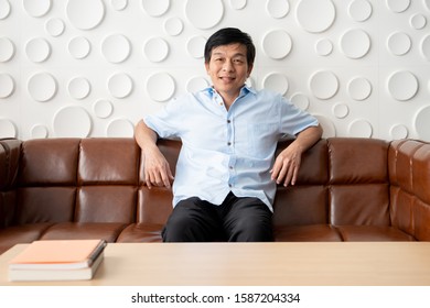 Elder Asian man relaxing in the living room, concept of leisure and aging society.