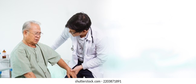 Elder Asian Man Sitting On The Bed And Talking To Doctor About His Physical Injuries At His Knees, Elderly Asian Man Having A Consulting With Professional Physical Therapist Or Orthopedic Doctor.