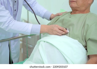 Elder Asian Man Sitting On The Bed And Talking To Doctor About His Physical Injuries At His Knees, Elderly Asian Man Having A Consulting With Professional Physical Therapist Or Orthopedic Doctor.