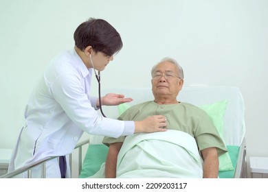 Elder Asian Man Sitting On The Bed And Talking To Doctor About His Physical Injuries At His Knees, Elderly Asian Man Having A Consulting With Professional Physical Therapist Or Orthopedic Doctor.