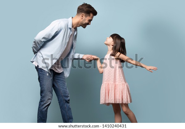 青い背景に手のポーズを持つピンクのドレスを着た幼い父親と小さな娘の王女が 一緒に楽しく過ごす兄妹ダンスワルツ の写真素材 今すぐ編集