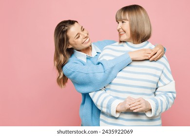 Elder cheerful parent mom 50s years old with young adult daughter two women together wear blue casual clothes hug look to each other isolated on plain pastel light pink background. Family day concept - Powered by Shutterstock