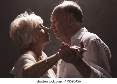 Elder Couple Dancing Close Together In A Dark Interior