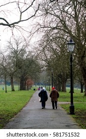 Elder Couple Walking Away In A Green Park