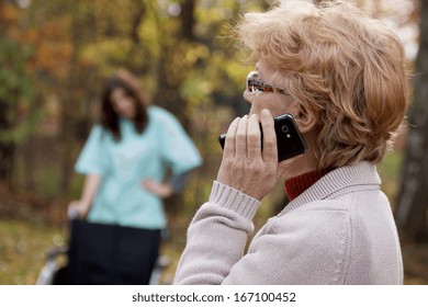 Elder disabled woman talking on the mobile phone - Powered by Shutterstock