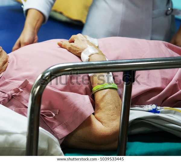 an elder female sleep on the bed in hospital a\
doctor stay beside