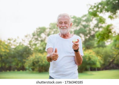 Elder Healthy Man Eating Apple Fruit In Plublic Park Morning.