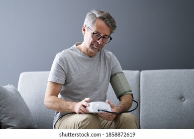 Elder Man Checking Blood Pressure At Home