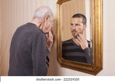elder man looking a younger himself in the mirror