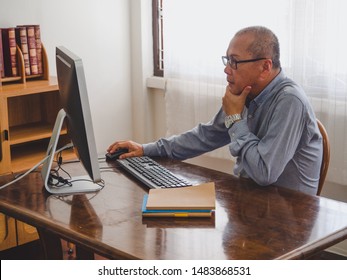 Elder Man Using Computer At Home