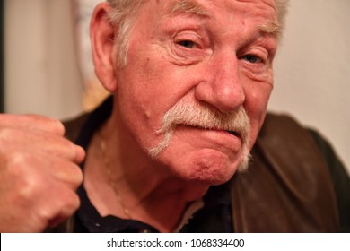 An Elder Man With A Walrus Mustache Threatens With His Fist To Start A Fight.