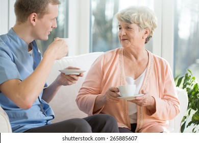 Elder Woman And Male Nurse Drinking Coffee