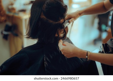 
Elder woman Straightens her Hair with a Straightener at Salon. Senior lady having her hair styled after trimming and coloring 
 - Powered by Shutterstock