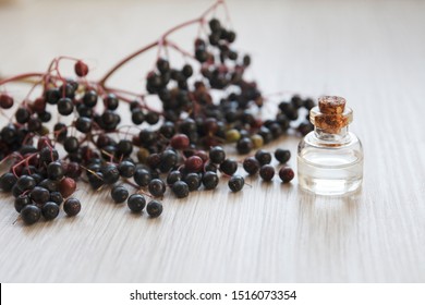 Elderberry Essential Oil (tincture, Extract, Infusion) With Fresh Elderberry On Wooden Background