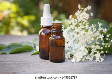 Elderberry Essential Oil (tincture, Extract) With Elderberry Flowers On Wooden Background