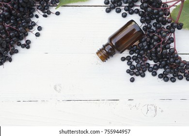 Elderberry Essential Oil (tincture, Extract, Infusion) With Fresh Elderberry On Wooden Background