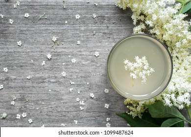 Elderflower syrup with flowers on white wooden table. healthy herbal drink. top view