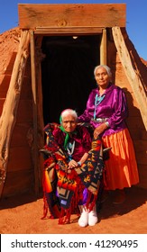 Elderly 99 Year Old Navajo Native American Woman And Her Daughter Standing In Front Of A Traditional Hogan