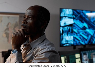 Elderly African American man thinking deeply in modern office filled with advanced technology and large screens depicting data. Hand on chin indicating contemplation and analysis - Powered by Shutterstock