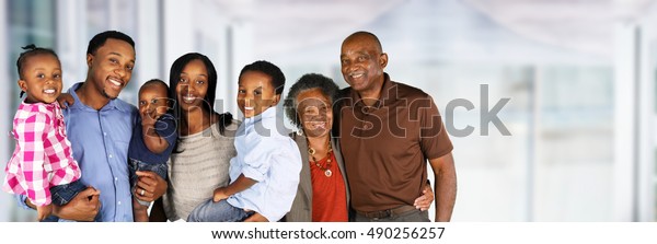 Elderly African American Man and woman posing\
together with their\
family