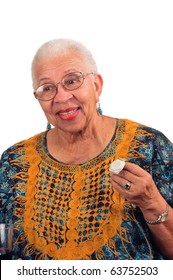 Elderly African American Woman With A Life Alert Device In Her Hand Showing The Comfort And Joy It Gives Her