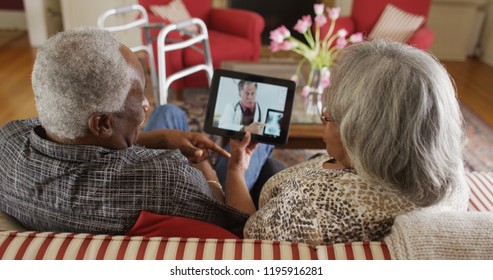 Elderly African couple video chat with a doctor on a tablet
