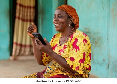 Elderly African Woman Using Her Smartphone Rejoices