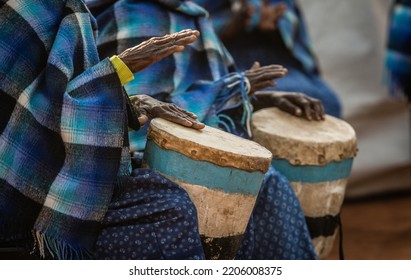 Elderly African Women Parading In African Blankets Attire, Playing Wooden Traditional Drums During A Traditional Wedding Ceremony