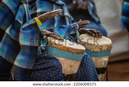 Elderly African Women Parading In African Blankets Attire, Playing Wooden Traditional Drums During A Traditional Wedding Ceremony