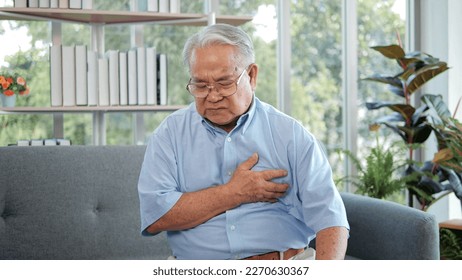 Elderly Asian man with chest pain suffering from heart attack. Man clutching his chest from acute pain. Heart attack symptom-Healthcare and medical concept - Powered by Shutterstock