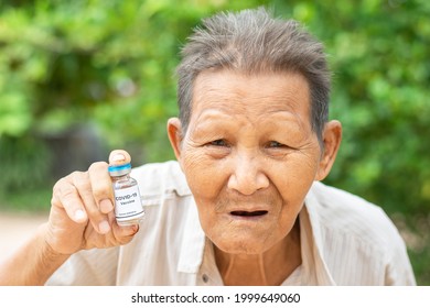 Elderly Asian Man Holding A Tube Of COVID-19 Vaccine (no Copyright Photo)