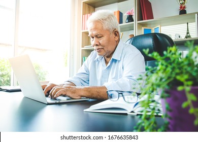 An Elderly Asian Man Sat To Work Typing A Notebook Computer In The Office. Concept Of Senior Employment, Social Security, Retirement