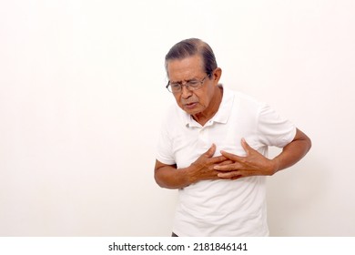 Elderly asian man standing while holds his chest, suffering from chest pain. Isolated on white - Shutterstock ID 2181846141