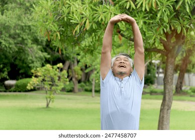 Elderly Asian man stretching his body before exercise and jogging in a park at the morning. Happy senior exercising outdoors in green garden. Active healthy elderly workout outside in nature backyard. - Powered by Shutterstock