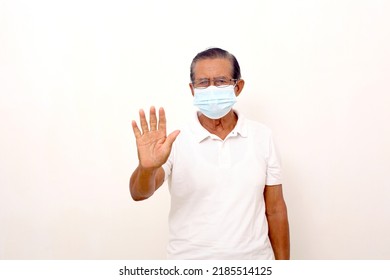 Elderly Asian Man Using Face Mask Standing With Stop Hand Gesture. Isolated On White