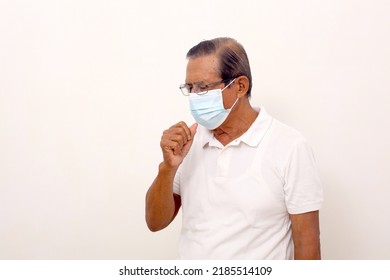 Elderly asian man wearing face mask standing while coughing. Isolated on white with copyspace - Powered by Shutterstock