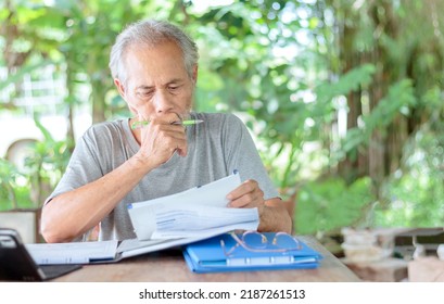 An Elderly Asian Man Working In The Garden At Home.