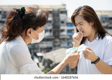 Elderly Asian People Chinese Is Sharing Mask To Woman Who Are Sick Of Cough,give Protective Mask To Reduce The Risk Of Spread Of Germs,Coronavirus Outbreak,epidemic Of Covid-19 Virus To Other People