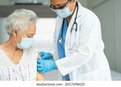 Elderly Asian Senior Woman Wearing Face Mask Getting Covid-19 Or Coronavirus Vaccine By Doctor Make Injection.