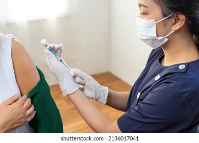 Elderly Asian woman getting coronavirus vaccine by nurse. Medical worker prepare syringe. - Powered by Shutterstock