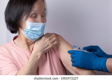 Elderly Asian Woman Getting COVID-19 Vaccine In Hospital. 