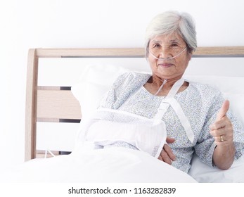   Elderly Asian Woman Laying On Bed In Hospital Room,she's Making Thumb Up And Smiling.