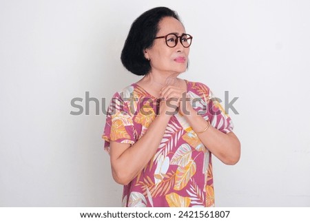 Elderly Asian woman looking away to the left with worried expression