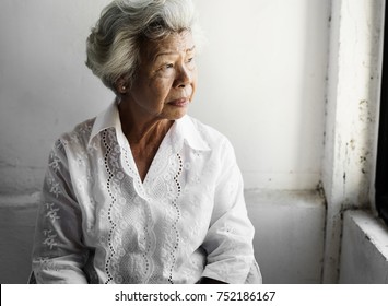 Elderly Asian Woman Looking Out Of The Window