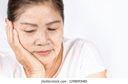 Elderly Asian Woman Portrait 60-70 Years Old With Black Hair And Hazel Eyes Looking Serious Thinking Isolated On White Background With Copy Space